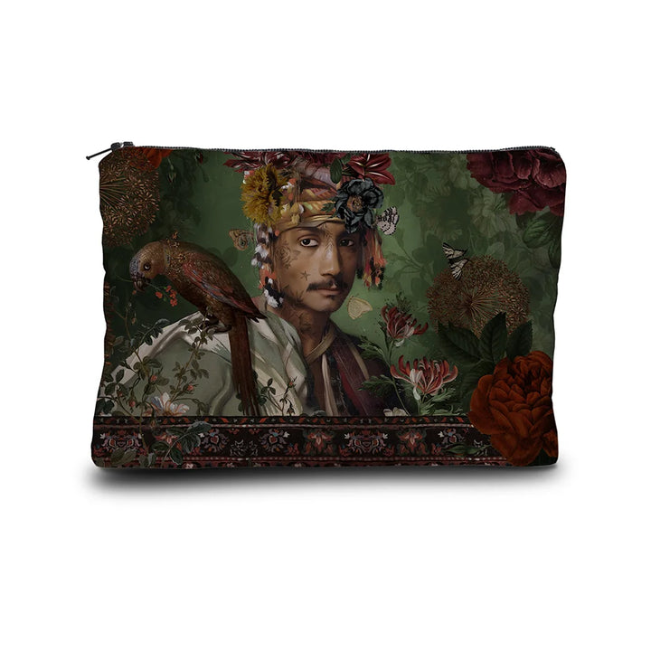 Kuvassa Voglio Bene -kukkaro Sultan-kuvituksella. Tatuoitu viiksekäs mies kukkaturbaani päässä ja papukaija olalla poseeraa vihreällä taustalla kukkien ympäröimänä.
The Voglio Bene purse with Sultan illustration. A tattooed man with a floral turban and a parrot on his shoulder poses against a green background surrounded by flowers.