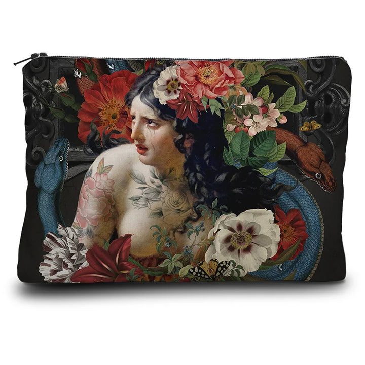 Kuvassa Voglio Bene kukkaron etupuoli Turmoil -kuvituksella, jossa itkevä tatuoitu nainen on kuvattuna kukkien ja käärmeiden ympäröimänä tummalla taustalla.
In the image, the front side of a Voglio Bene purse with the Turmoil illustration, depicting a crying tattooed woman surrounded by flowers and snakes against a dark background.