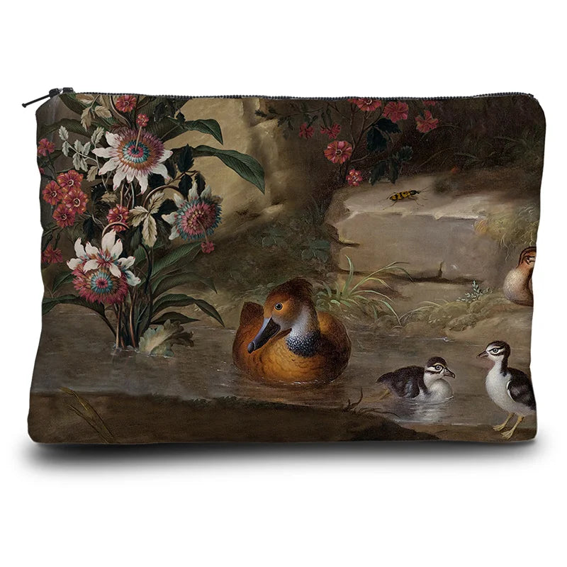 Kuvassa Voglio Bene kukkaron takapuoli Zebra and Co -kuvituksella, jossa näkyy kukkia ja vesilintuja.
In the image, the back side of a Voglio Bene purse with the Zebra and Co illustration, showing flowers and water birds.