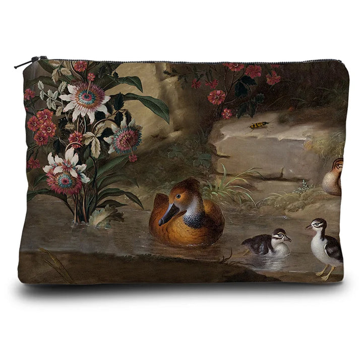 Kuvassa Voglio Bene kukkaron takapuoli Zebra and Co -kuvituksella, jossa näkyy kukkia ja vesilintuja.
In the image, the back side of a Voglio Bene purse with the Zebra and Co illustration, showing flowers and water birds.