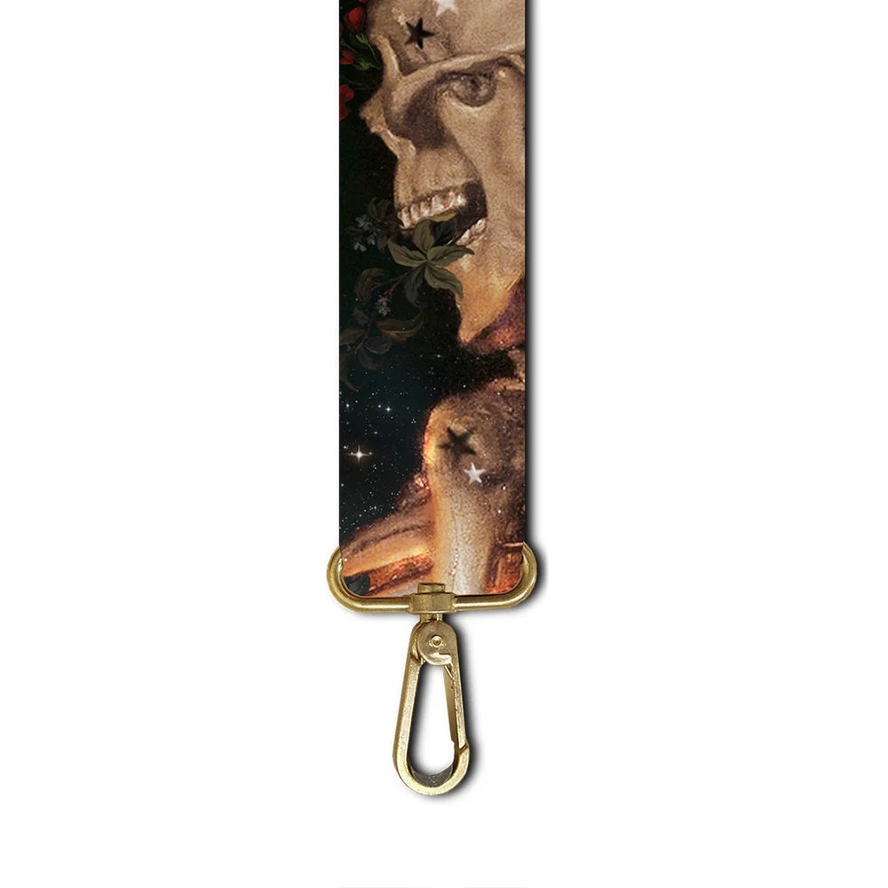 Kuvassa vihreä Voglio Bene -olkahihna La Vida -kuvituksella. Hihnassa on värikkäitä kukkia ja tyylitelty luurangon sivuprofiili koristeellisena elementtinä.
Illustration of a green Voglio Bene shoulder strap with the La Vida artwork. The strap features colorful flowers and a stylized side profile of a skeleton.