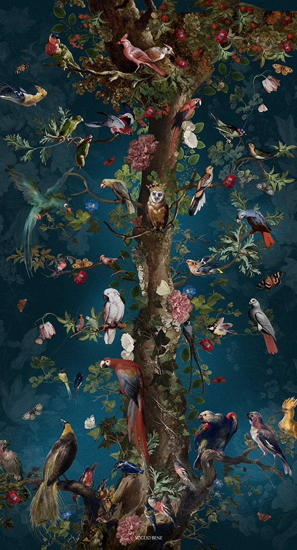 Kuvassa Voglio Bene seinävaate Tree of Life -kuvituksella. Puu kohoaa sinisellä taustalla, sen oksalla istuu kruunupäinen pöllö ja ympärillä on runsaasti trooppisia lintuja.
The Voglio Bene tapestry with Tree of Life illustration. A tree rises against a blue background, with an owl wearing a crown perched on a branch, surrounded by tropical birds.