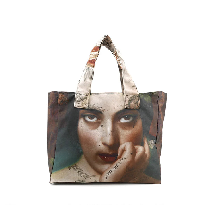 Kuvassa Voglio Bene tote bag takapuoli Clementine -kuvituksella, jossa näkyy lähikuva naisen silmistä.
In the image, the back side of a Voglio Bene tote bag with the Clementine illustration, showing a close-up of the woman’s eyes.