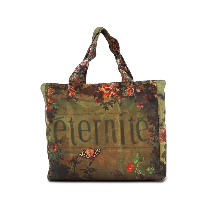 Kuvassa Voglio Bene tote bag takapuoli Eternity -kuvituksella, jossa vihreällä taustalla lukee “Éternité” ja ympärillä on kukkia.
In the image, the back side of a Voglio Bene tote bag with the Eternity illustration, showing the word “Éternité” on a green background with flowers around it.