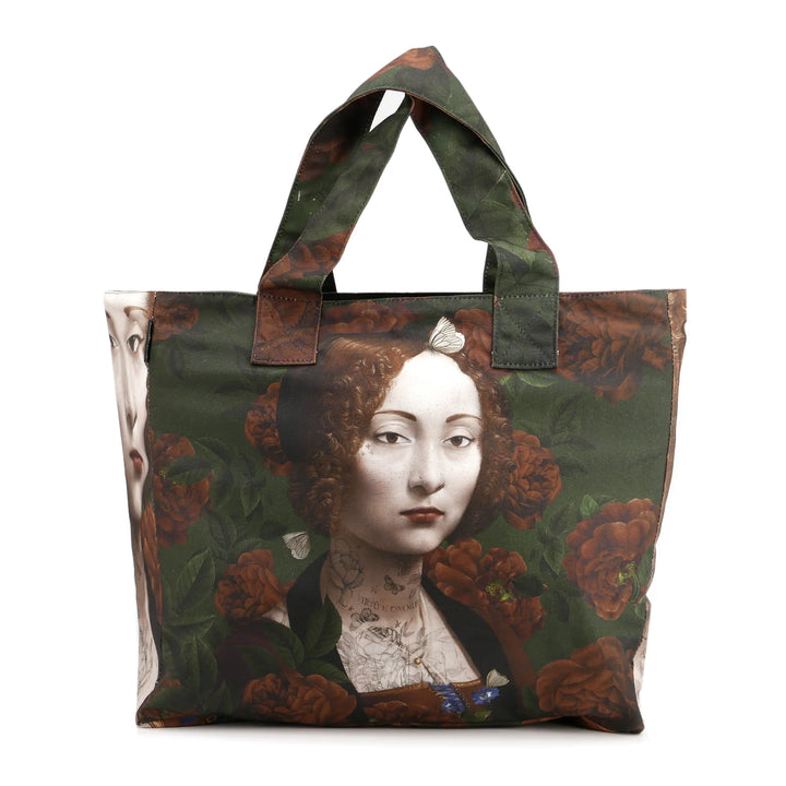 Voglio Bene Ginevra -tote bag etunäkymä, jossa Ginevra-hahmo on kuvattuna yksityiskohtaisessa kuvituksessa.
English: Front view of a Voglio Bene Ginevra tote bag, showing the Ginevra figure in detailed artwork.