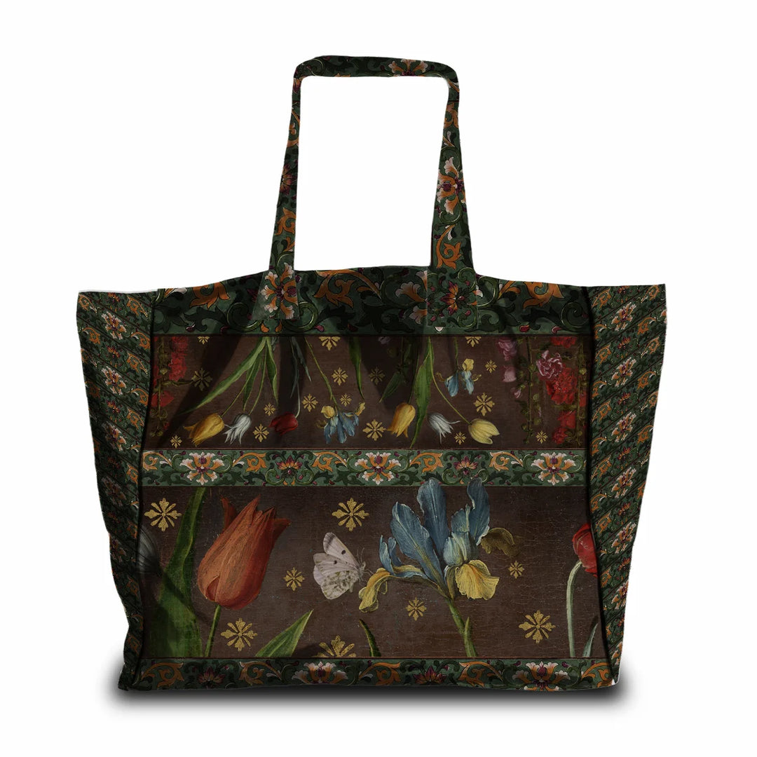 Kuvassa Voglio Bene -tote bag takapuoli Jolly-kuvituksella. Kukat ja ornamenttikuvio ruskealla taustalla.
The back of the Voglio Bene tote bag with the Jolly illustration. Flowers and ornamental patterns on a brown background.