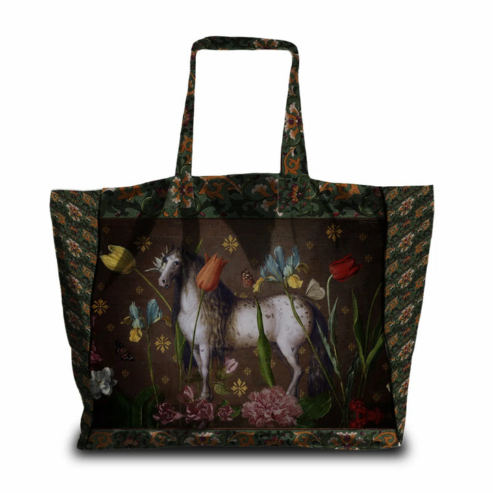Kuvassa Voglio Bene -tote bag Jolly-kuvituksella. Tatuoitu hevonen ruskealla taustalla kukkien ja perhosten ympäröimänä.
The Voglio Bene tote bag with the Jolly illustration. A tattooed horse on a brown background surrounded by flowers and butterflies.