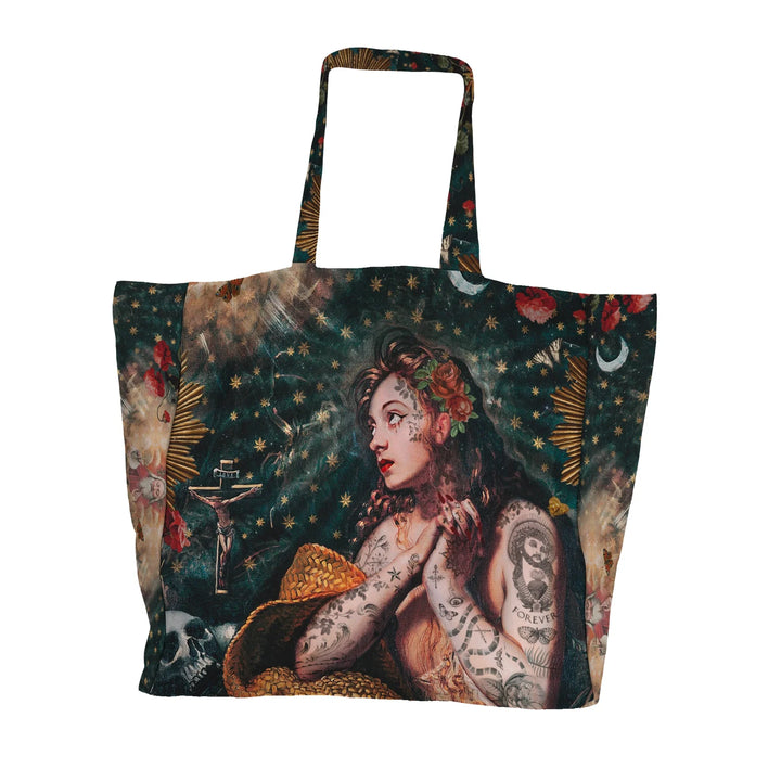 Voglio Bene Marie Magdeline -tote bag etunäkymä. Kuvassa tatuoitu nainen rukoilee katse suunnattuna taivaaseen. Hänen vierellään on krusifiksi, ja taustalla näkyy pääkallo sekä tähtiä.
Front view of a Voglio Bene Marie Magdeline tote bag. The illustration shows a tattooed woman praying toward the sky, with a crucifix beside her and a skull and stars in the background.