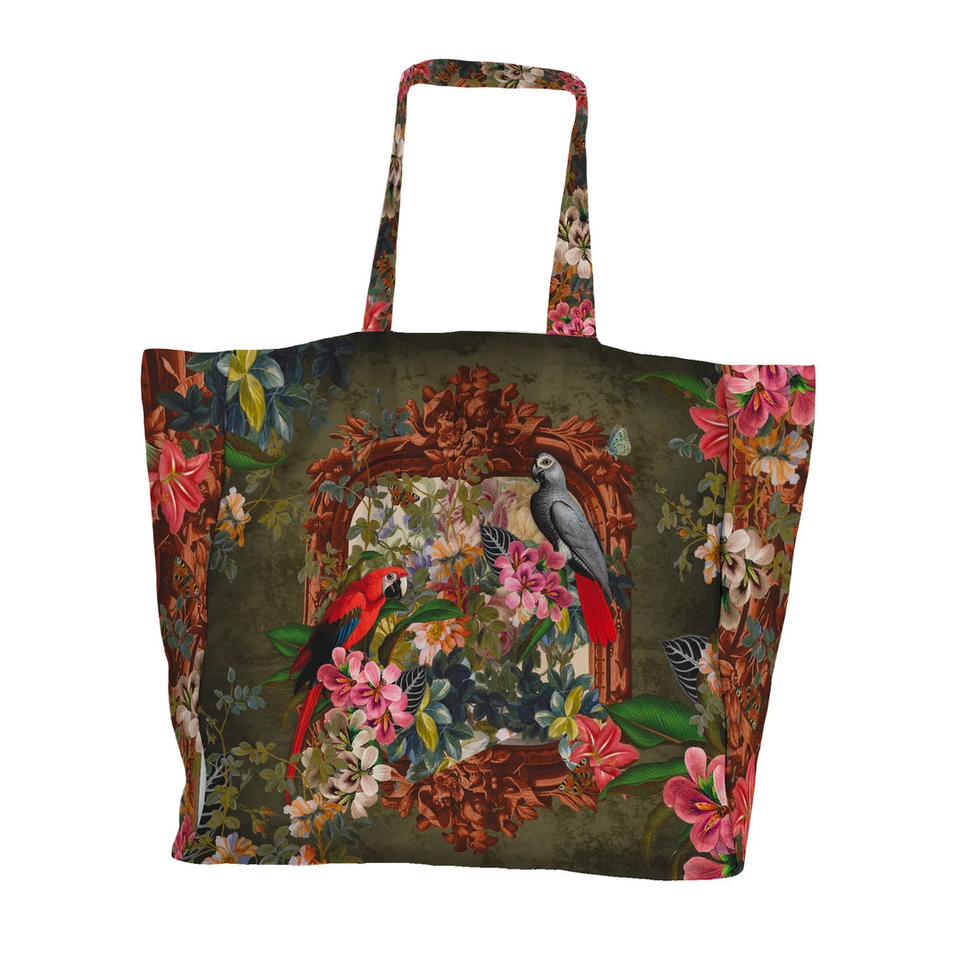 Voglio Bene Parrot -tote bag etunäkymä. Kuvassa kaksi papukaijaa istuu kukkaornamentti-asetelmassa rehevän taustan edessä.
Front view of a Voglio Bene Parrot tote bag. The illustration shows two parrots perched within a floral ornamental arrangement against a lush backdrop.