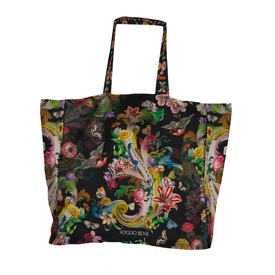 Voglio Bene Rock Flowers -tote bag etunäkymä, jossa kukkia ja lintu on kuvattuna yksityiskohtaisessa kuvituksessa.
Front view of a Voglio Bene Rock Flowers tote bag, showing flowers and a bird in detailed artwork.