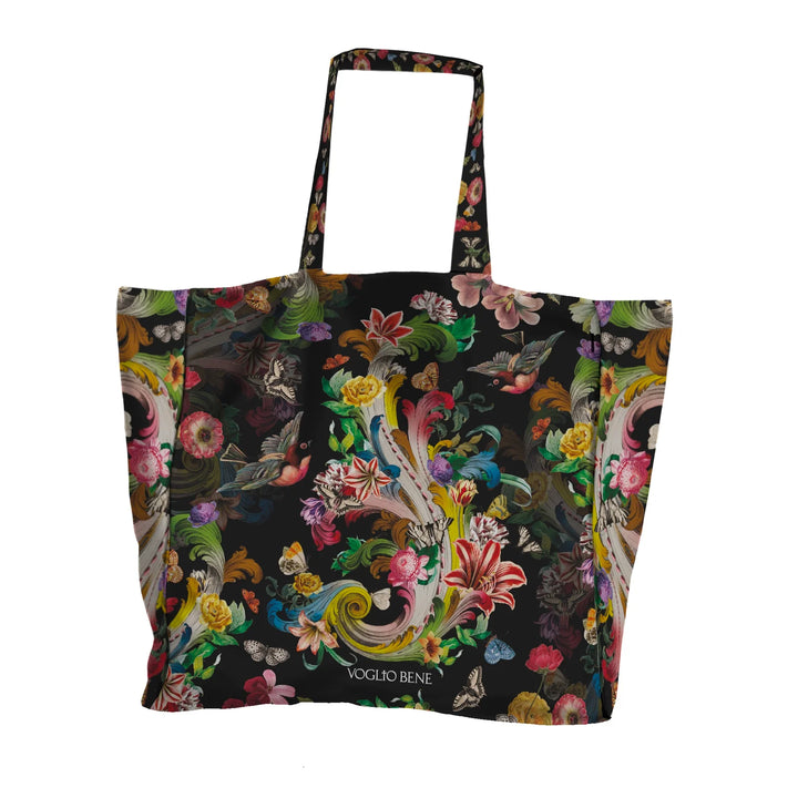 Voglio Bene Rock Flowers -tote bag etunäkymä, jossa kukkia ja lintu on kuvattuna yksityiskohtaisessa kuvituksessa.
Front view of a Voglio Bene Rock Flowers tote bag, showing flowers and a bird in detailed artwork.