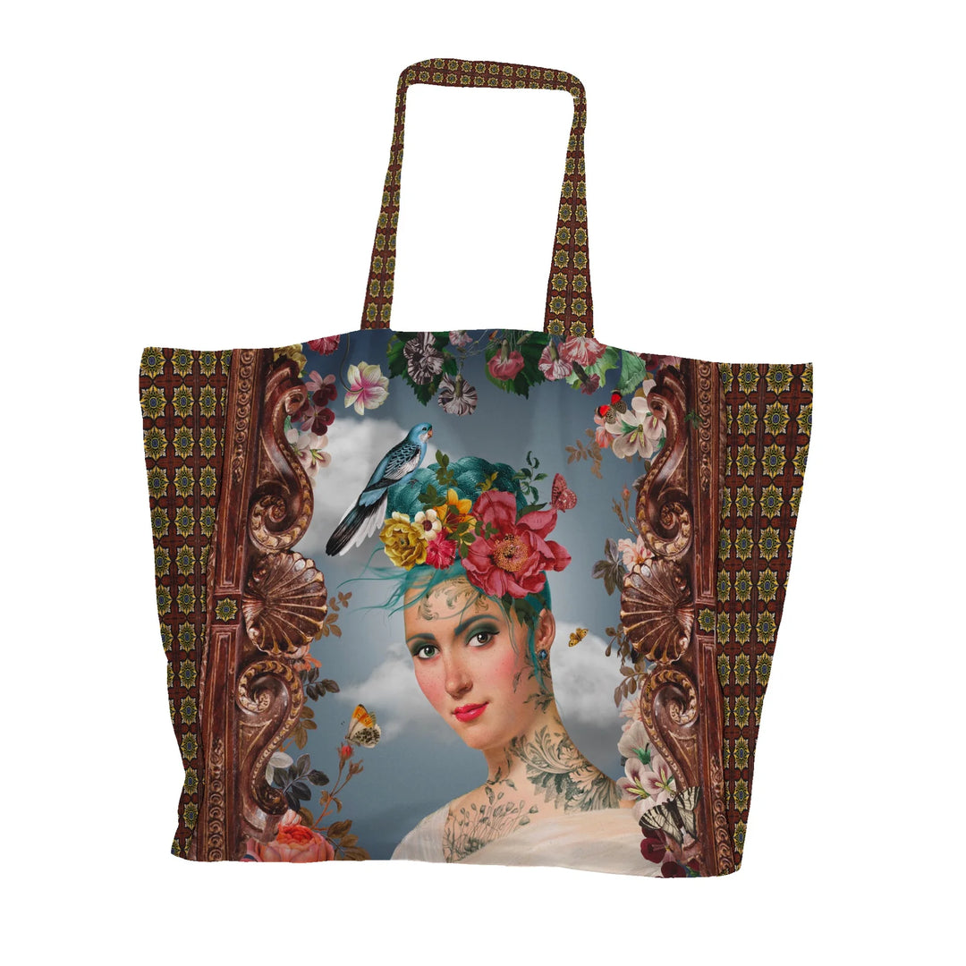 Voglio Bene Spring -tote bag etunäkymä, jossa sinihiuksinen tatuoitu nainen on kuvattu lintu ja kukkia hiuksissaan.
Front view of a Voglio Bene Spring tote bag, showing a blue-haired tattooed woman with a bird and flowers in her hair.