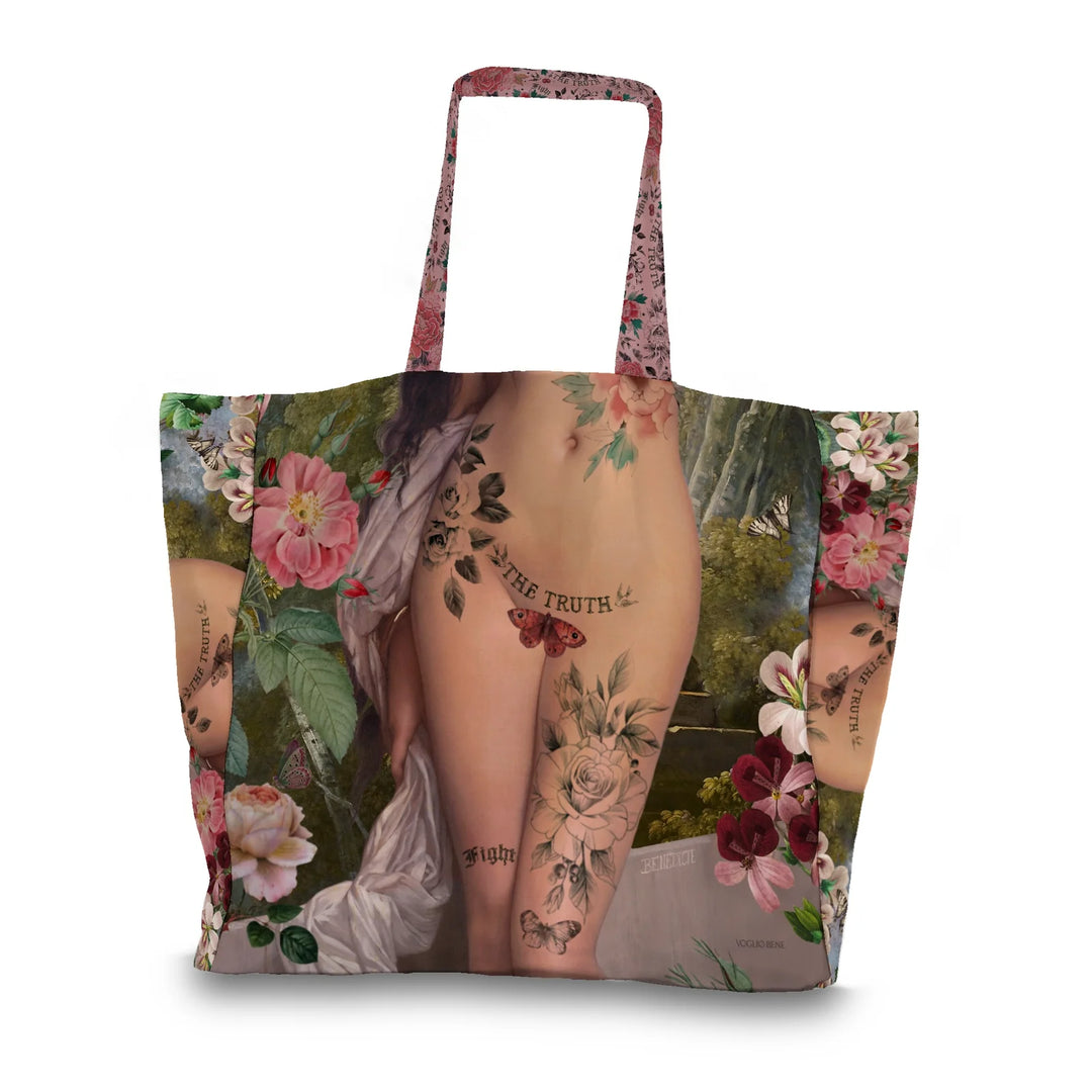 Kuvassa Voglio Bene tote bagin takapuoli The Truth -kuvituksella. Tatuoidun alastoman naisen lantio kukkien ja perhosten ympäröimänä.
The back of the Voglio Bene tote bag with The Truth illustration. The tattooed hips of a nude woman surrounded by flowers and butterflies.