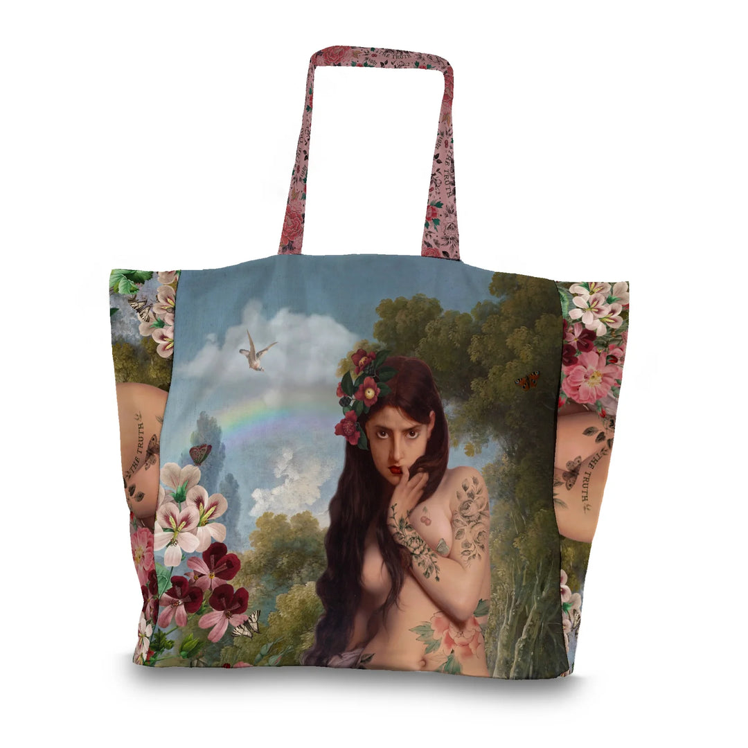 Kuvassa Voglio Bene tote bagin etupuoli The Truth -kuvituksella. Tatuoitu alaston nainen seisoo metsässä sinisen taivaan ja sateenkaaren alla.
The front of the Voglio Bene tote bag with The Truth illustration. A tattooed nude woman stands in a forest beneath a blue sky and a rainbow.