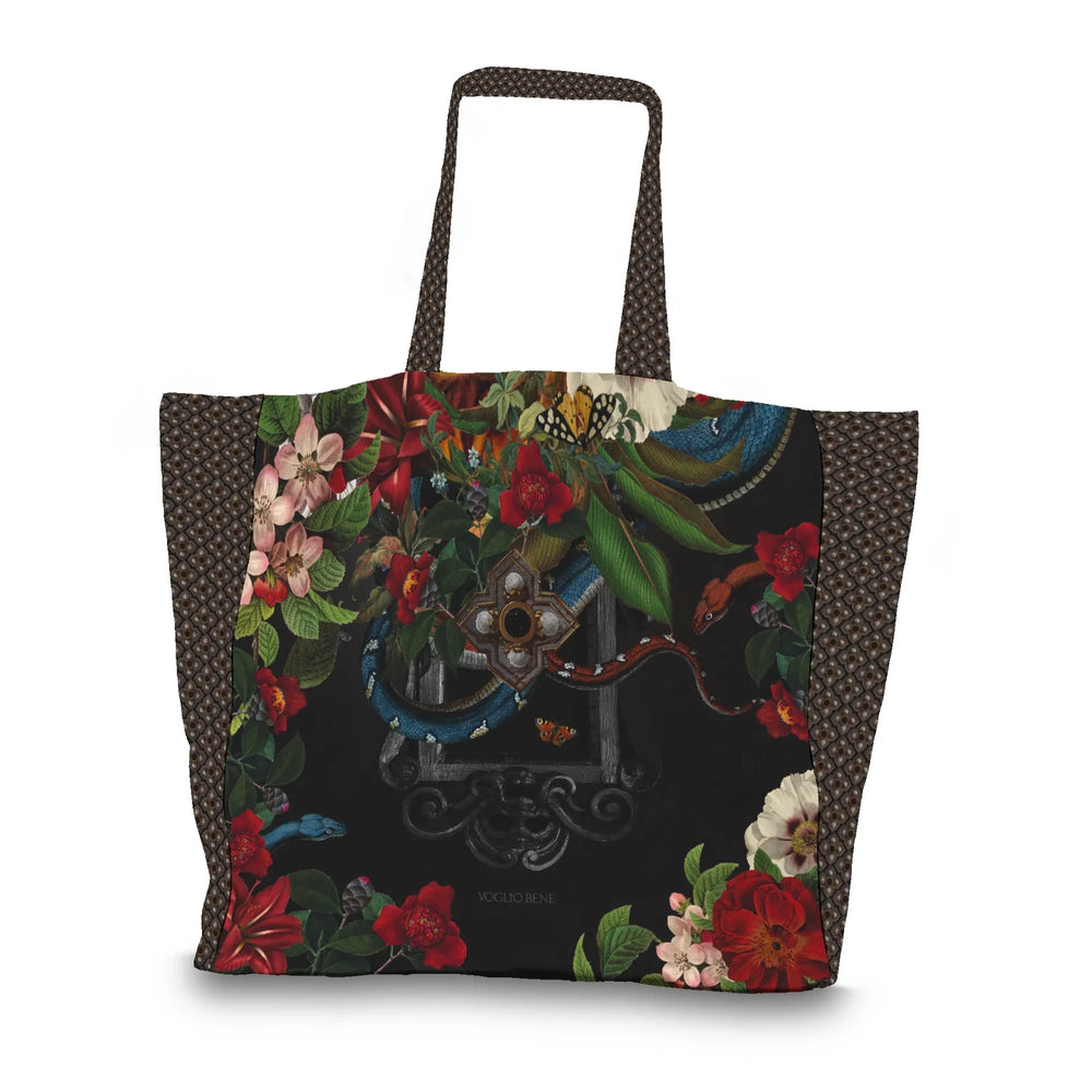 Kuvassa Voglio Bene tote bag takapuoli Turmoil -kuvituksella, jossa tumma peili on kukkien ja käärmeiden ympäröimänä.
In the image, the back side of a Voglio Bene tote bag with the Turmoil illustration, showing a dark mirror framed by flowers and snakes.