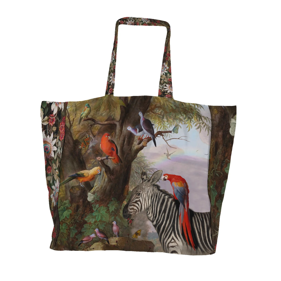 Kuvassa Voglio Bene tote bag etupuoli Zebra and Co -kuvituksella, jossa seepra on kuvattuna trooppisten lintujen ja perhosten kanssa vehreässä metsässä.
In the image, the front side of a Voglio Bene tote bag with the Zebra and Co illustration, featuring a zebra among tropical birds and butterflies in a lush forest.