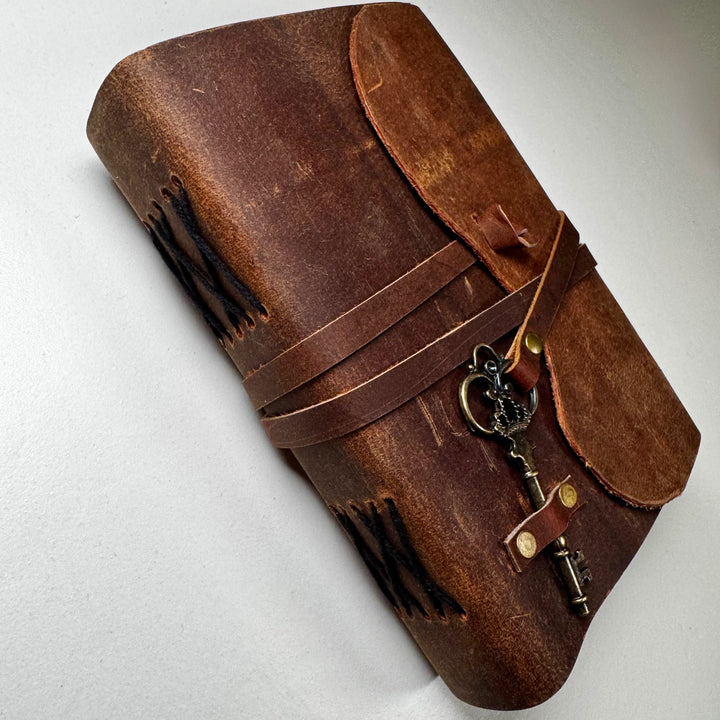 Vintage Leather nahkakantinen muistikirja sivusta kuvattuna, esillä kirjan paksuus ja sidonta. - The Vintage Leather notebook photographed from the side, showing the book’s thickness and binding.