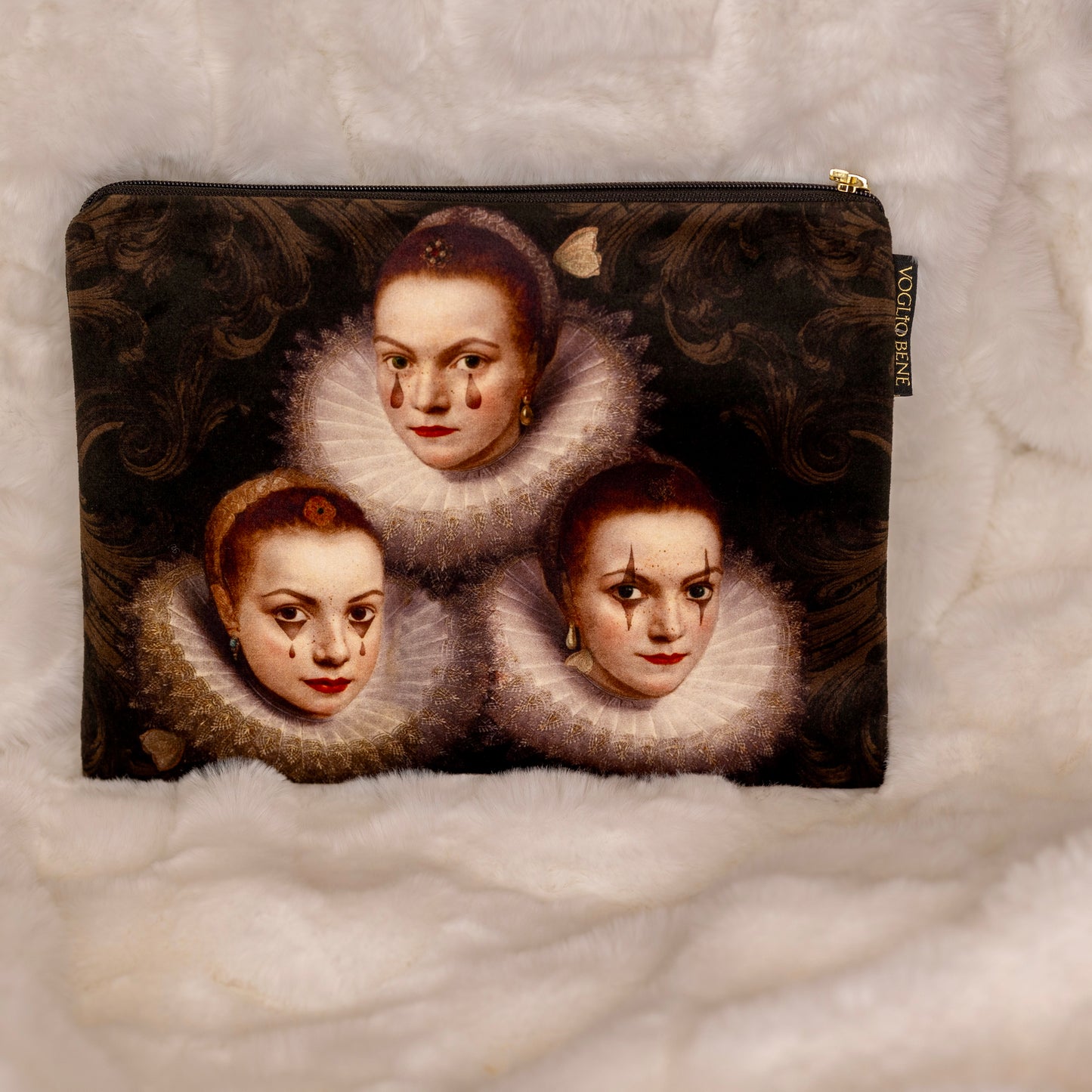 Kolme renessanssinaista yksityiskohtaisilla kasvonpiirteillä, symboloiden yhteisöllisyyttä ja yksilöllisyyttä. Kuvattu Voglio Benen samettipussukassa. - Three Renaissance women with detailed features, symbolizing community and individuality, depicted on a velvet pouch by Voglio Bene.