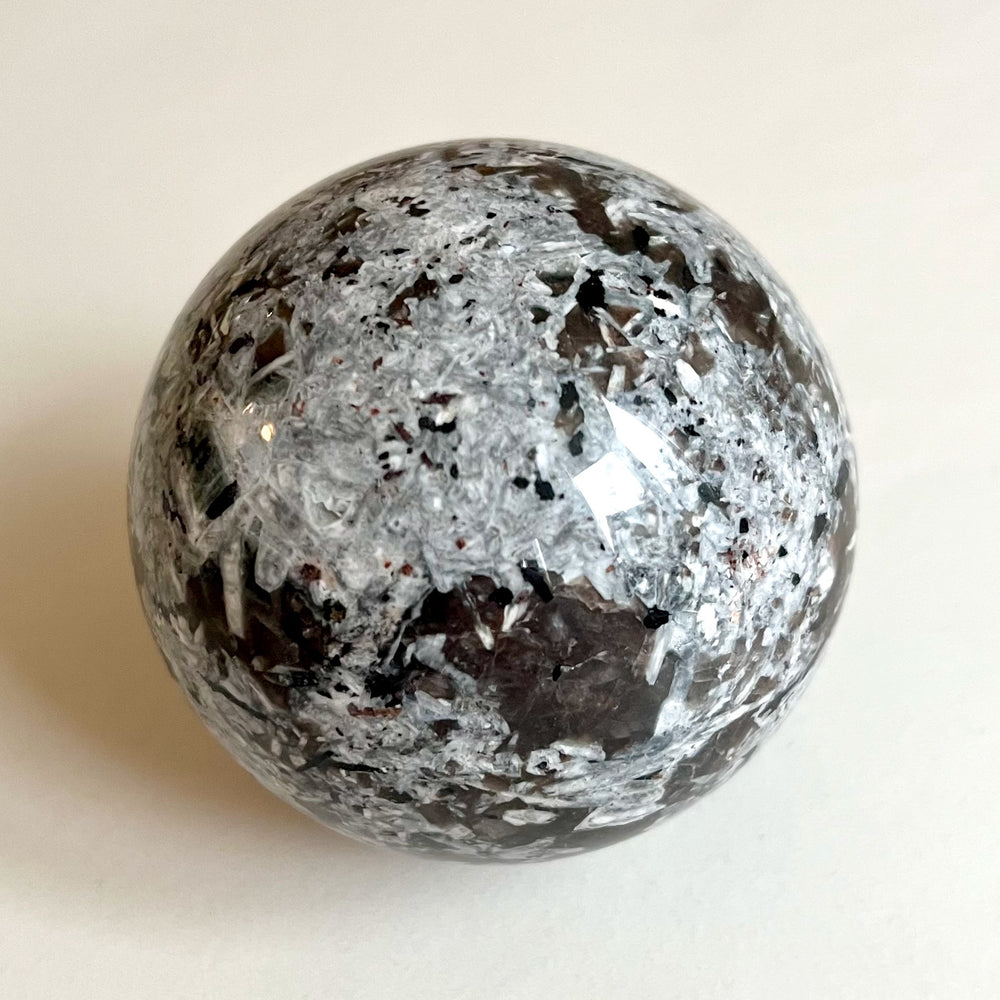 Harmaa Yooperlite-kivi ilman UV-valon vaikutusta, harmaan- ja ruskeankirjava.
Grey and brown Yooperlite stone without UV light, smooth surface.