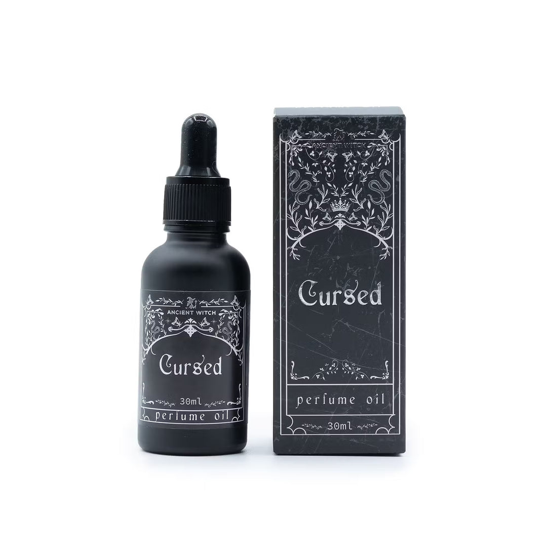 Cursed-parfyymiöljy 30 ml mustassa pipettipullossa ja hopeansävyisin kuvioin koristeltu rasia. / Cursed perfume oil 30 ml in a black dropper bottle with its silver-patterned box.