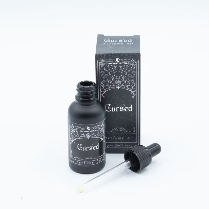 Avattu Ancient Witch Cursed -parfyymiöljypullo, lasipipetti ja pakkaus. / Open Ancient Witch Cursed perfume oil bottle with glass dropper and box.