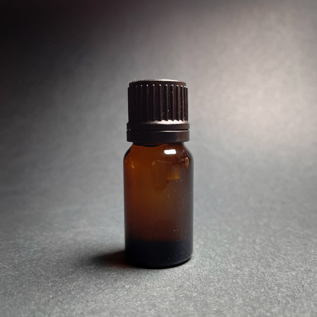 Sitruunan eteeristä öljyä ruskeassa 10 ml:n lasipullossa, jossa on musta kierrekorkki, harmaalla taustalla.
