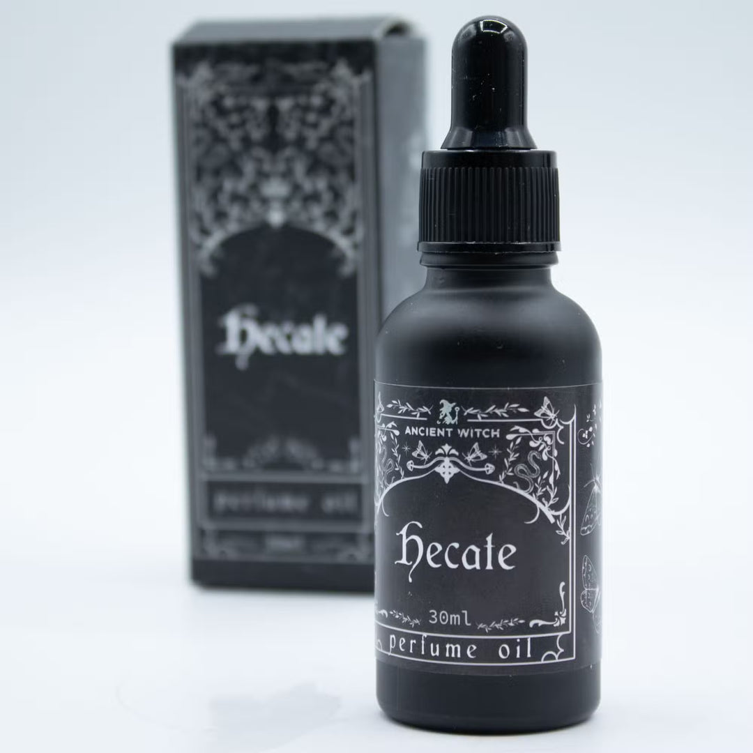 Hecate-parfyymiöljyn musta 30 ml pipettipullo lähikuvassa. / Close-up of the black 30 ml Hecate perfume oil dropper bottle.