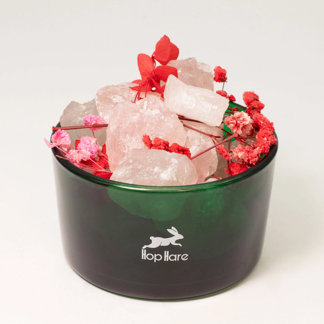 Hop Hare The Lovers crystal diffuser in a dark green glass vessel with rose quartz and dried flowers.
