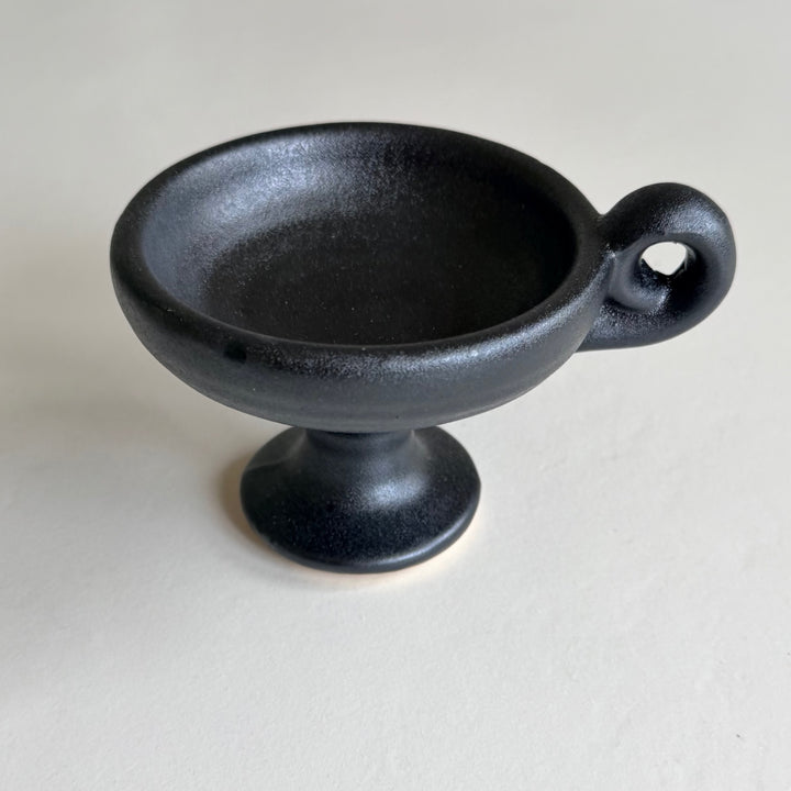 Black pedestal ceramic incense burner viewed from above at an angle.
