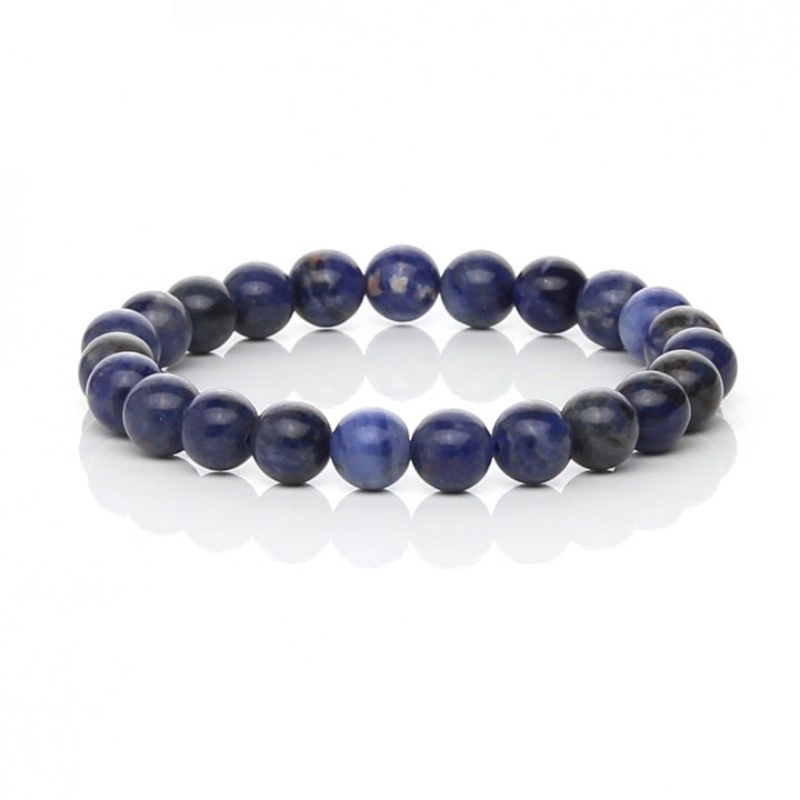 Bracelet made from round blue sodalite beads on a white background.