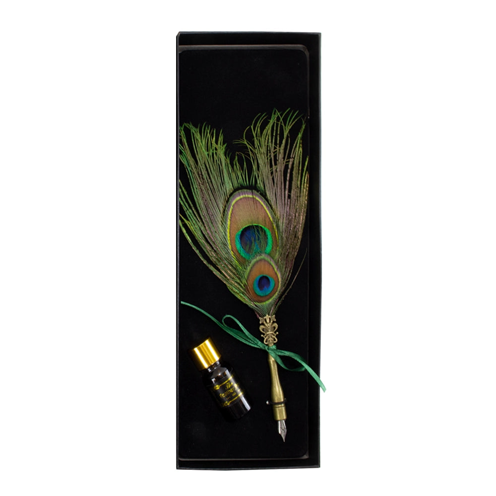Peacock feather quill pen and a bottle of ink in an open black gift box.