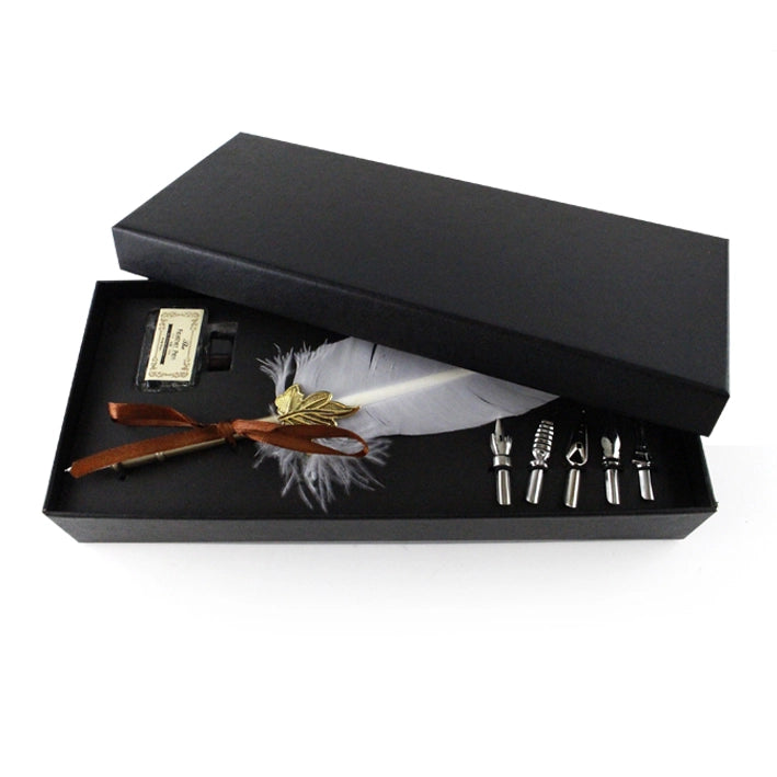 White feather quill pen set in a black gift box with the lid partly open.