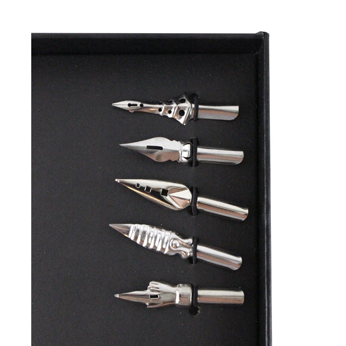 Close-up of the white feather quill pen set’s five different interchangeable metal nibs.