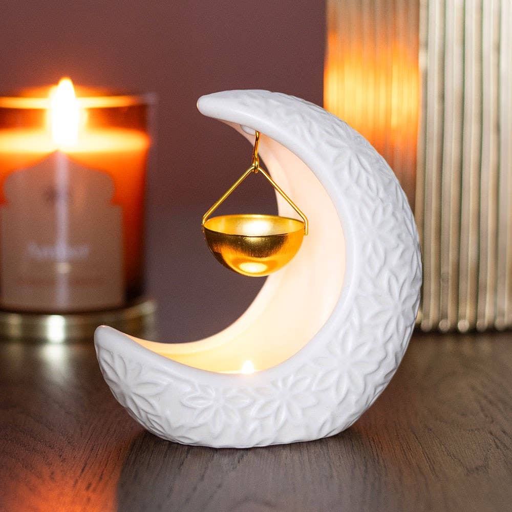 White Crescent Moon oil burner in use, with a gold-coloured bowl suspended inside the crescent above a tealight.