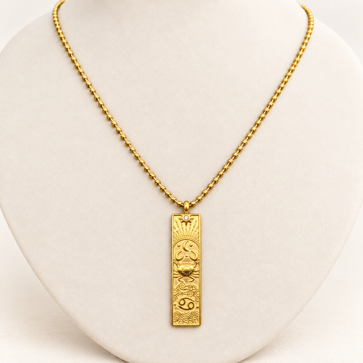 18K gold-plated Zodiac necklace, Cancer, on a light-coloured jewellery bust.