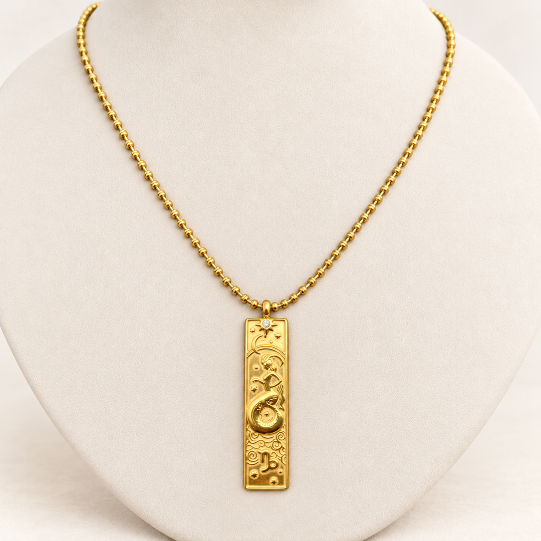18K gold-plated Zodiac necklace, Capricorn, on a light-coloured jewellery bust.