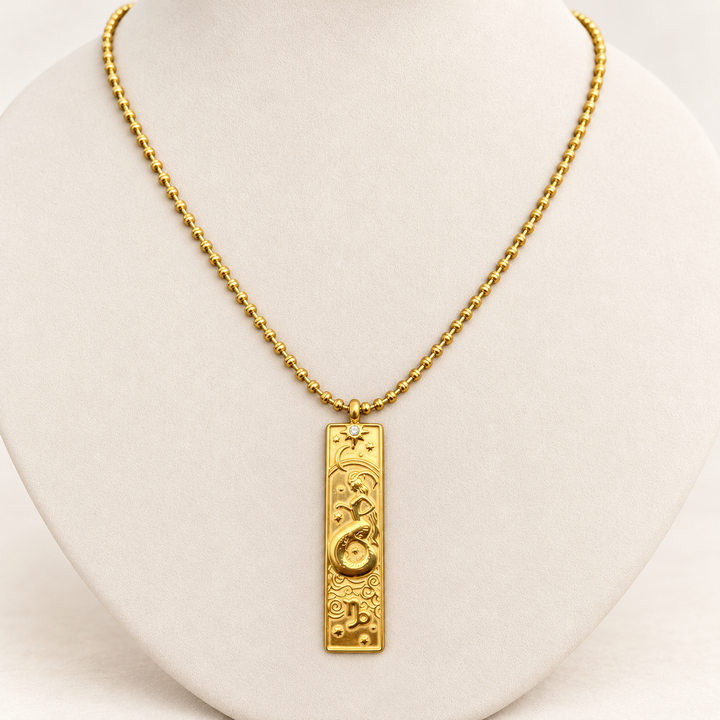 18K gold-plated Zodiac necklace, Capricorn, on a light-coloured jewellery bust.